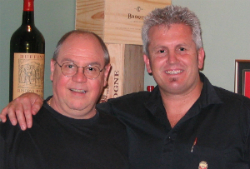 Bob Monica in a black shirt standing to the left of Stuart Devine who is wearing a black collared shirt.