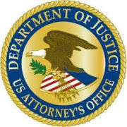 Round logo with an eagle and American Flag on a shield in the middle. The text Department of Justice US Attorney's Office goes around the image.